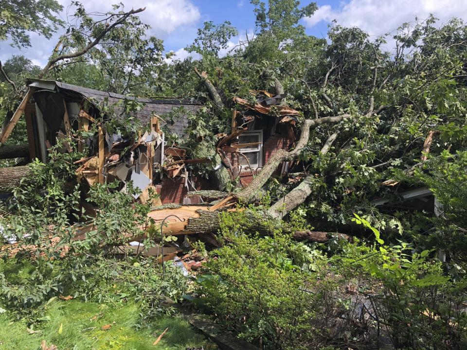 Fallen trees smother a damaged home, Tuesday, June 25, 2019, in Charleston, W.Va. The National Weather Service says storm-related damage indicates a rare tornado touched down in West Virginia. (Chad Hedrick/WSAZ-TV via AP)