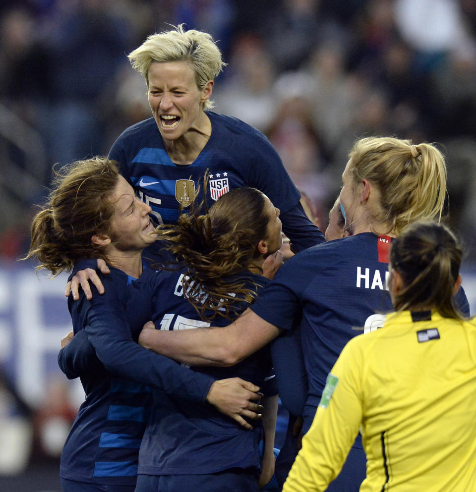 United States forward Megan Rapinoe, top, celebrates with Tierna Davidson, left, and Tobin Heath, center, after Heath scored a goal against England during the second half of a SheBelieves Cup women's soccer match Saturday, March 2, 2019, in Nashville, Tenn. (AP Photo/Mark Zaleski)