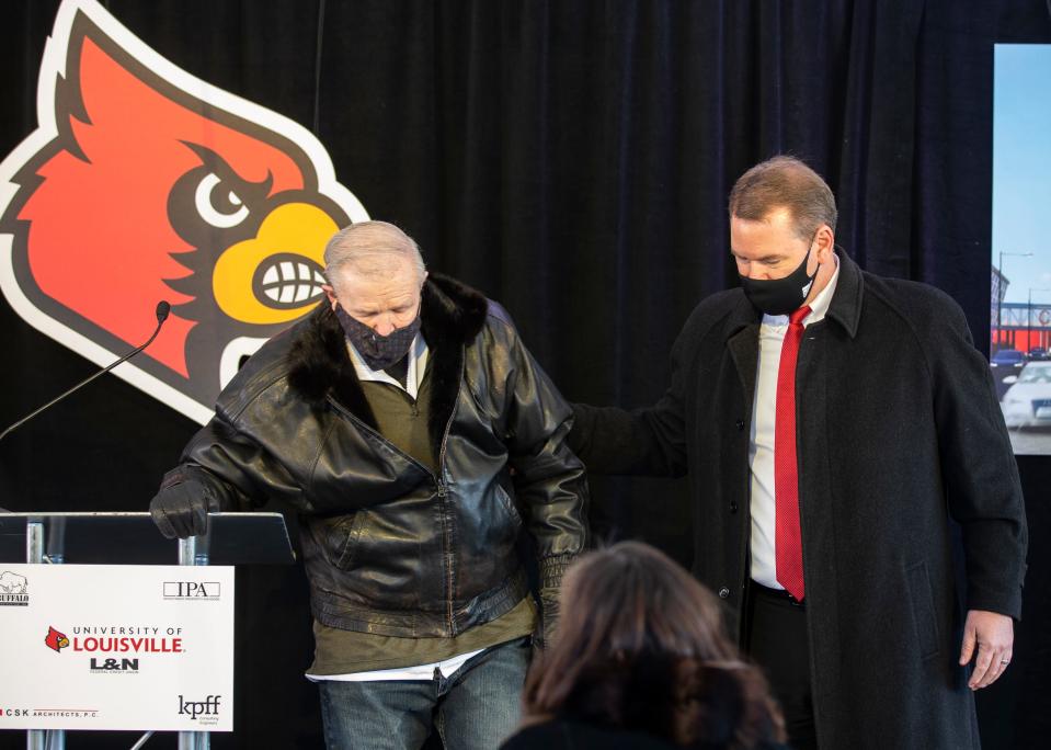 University of Louisville Athletic Director Vince Tyra helps former UofL and Hall of Fame basketball coach Denny Crum back to his seat during the ceremonial ground breaking for a new on campus housing complex named in his honor. March 2, 2021.