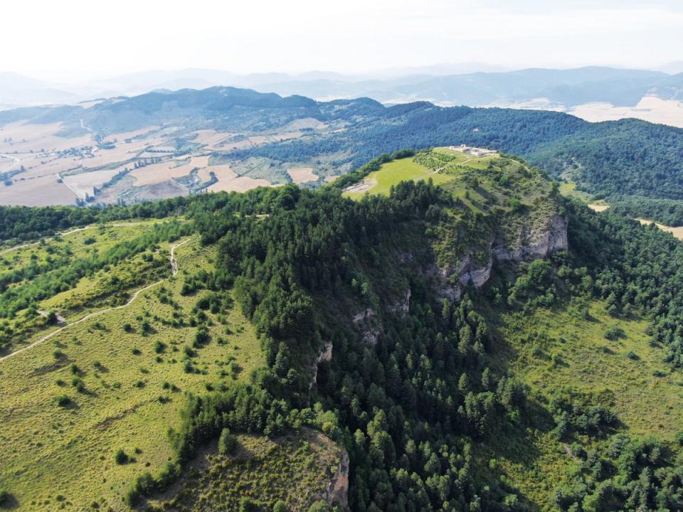 Dramatic photograph showing the mountaintop location of the ancient Basque fortified settlement - and the cliffs which surround it on three sides. (Aranzadi Science Society)