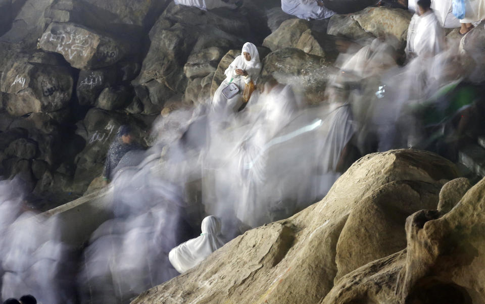 In this picture taken with low shutter speed, Muslim pilgrims make their way up on a rocky hill known as Mountain of Mercy, on the Plain of Arafat, during the annual hajj pilgrimage, ahead of sunrise near the holy city of Mecca, Saudi Arabia, Saturday, Aug. 10, 2019. More than 2 million pilgrims were gathered to perform initial rites of the hajj, an Islamic pilgrimage that takes the faithful along a path traversed by the Prophet Muhammad some 1,400 years ago. (AP Photo/Amr Nabil)