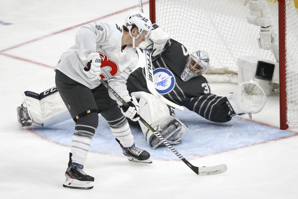 San Jose Sharks forward Tomas Hertl scores a goal against Winnipeg Jets goalie Connor Hellebuyck (37) during their NHL All-Star semifinal game Saturday, Jan. 25, 2020, in St. Louis. (AP Photo/Scott Kane)