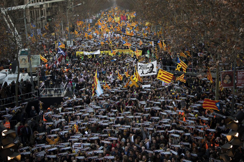 Pro independence demonstrators hold banners that says in Catalan "self-determination is not a crime", during a demonstration supporting the imprisoned pro-indenpence political leaders in Barcelona, Spain, Saturday, Feb. 16, 2019. Thousands of Catalan separatists are marching in Barcelona to proclaim the innocence of 12 of their leaders who are on trial for their role in a failed 2017 secession bid. (AP Photo/Emilio Morenatti)