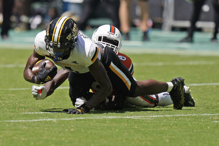 Southern Miss wide receiver Jason Brownlee is taken down by Miami cornerback DJ Ivey (8) during the second half of an NCAA college football game, Saturday, Sept. 10, 2022, in Miami Gardens, Fla. (AP Photo/Wilfredo Lee)