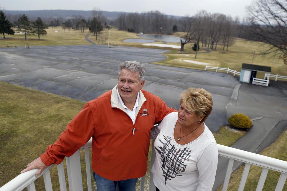 In this March 20, 2014 photo, Bruce Clingan, left, and his wife Jody stand for a photo on the deck of their home at their Tanglewood Golf Course in Pulaski, Pa. The Clingans are part of a group of property owners in the area that signed a lease with gas drilling company Hilcorp that is hoping to start collecting royalty checks from the gas under their land. Hilcorp has asked state officials to invoke a 1961 law in the rural area and allow Utica Shale well bores under the property of four landowners who haven’t signed leases. (AP Photo/Keith Srakocic)