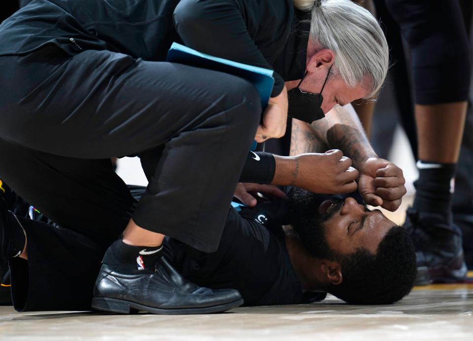 Miami Heat forward Markieff Morris, bottom, is attended to after being in an altercation with Denver Nuggets center Nikola Jokic on Monday, Nov. 8, 2021, in Denver. Morris walked off the court after being examined and Jokic was ejected.