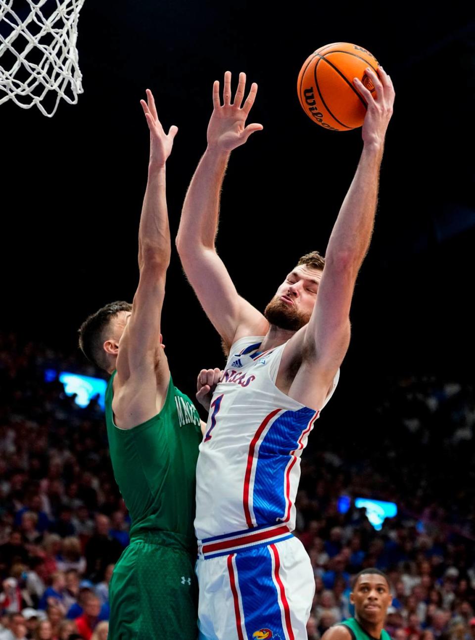 Kansas Jayhawks center Hunter Dickinson shoots around Manhattan Jaspers guard Brett Rumpel during Friday night’s game at Allen Fieldhouse.