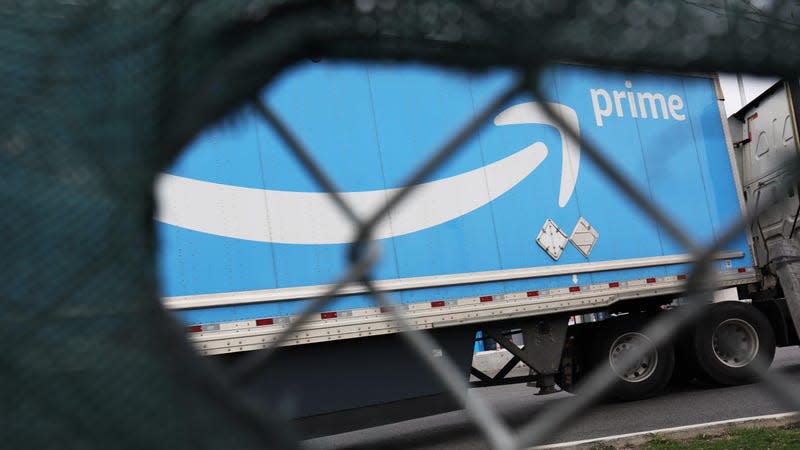 An Amazon prime truck behind a chainlink fence.