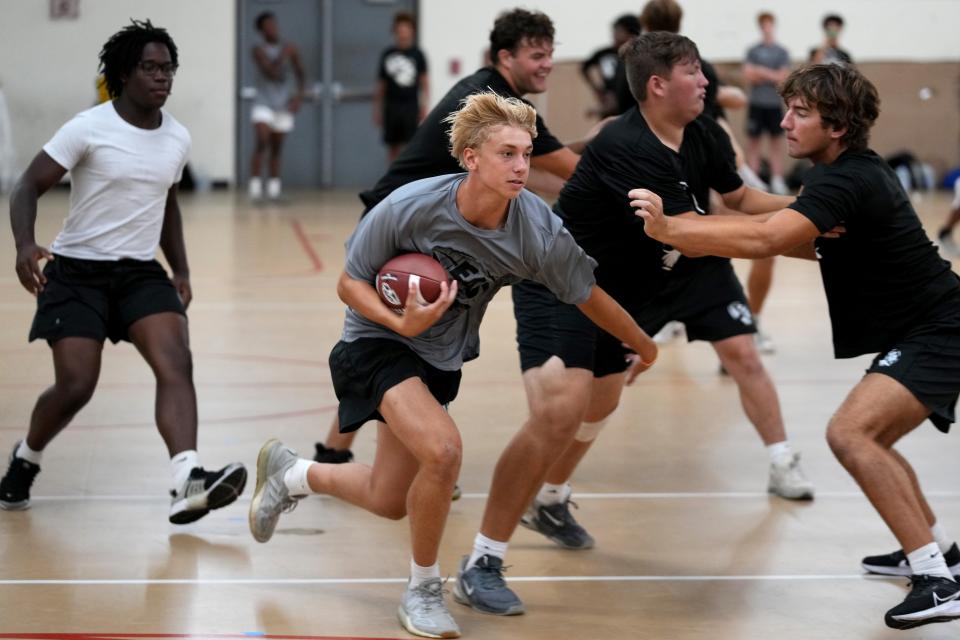 Lakota East wide receiver Andy Vogelman carries the ball during practice inside the school’s gym Monday.