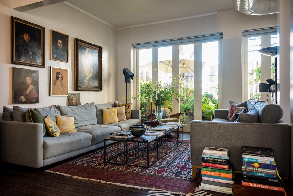 In the living space, the iron tables were crafted by a local artist and the wall above the sofa showcases a collection of paintings by 19th-century art students.