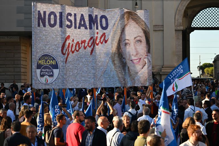 Militantes sostienen el 22 de septiembre de 2022 un cartel de campaña de la líder de Fratelli d'Italia, Giorgia Meloni, antes de un mitin conjunto de los partidos de derecha italianos Hermanos de Italia (Fratelli d'Italia, FdI), la Liga (Lega) y Forza Italia en la Piazza del Popolo en Roma, antes de las elecciones generales del 25 de septiembre. (Foto de Andreas SOLARO / AFP)