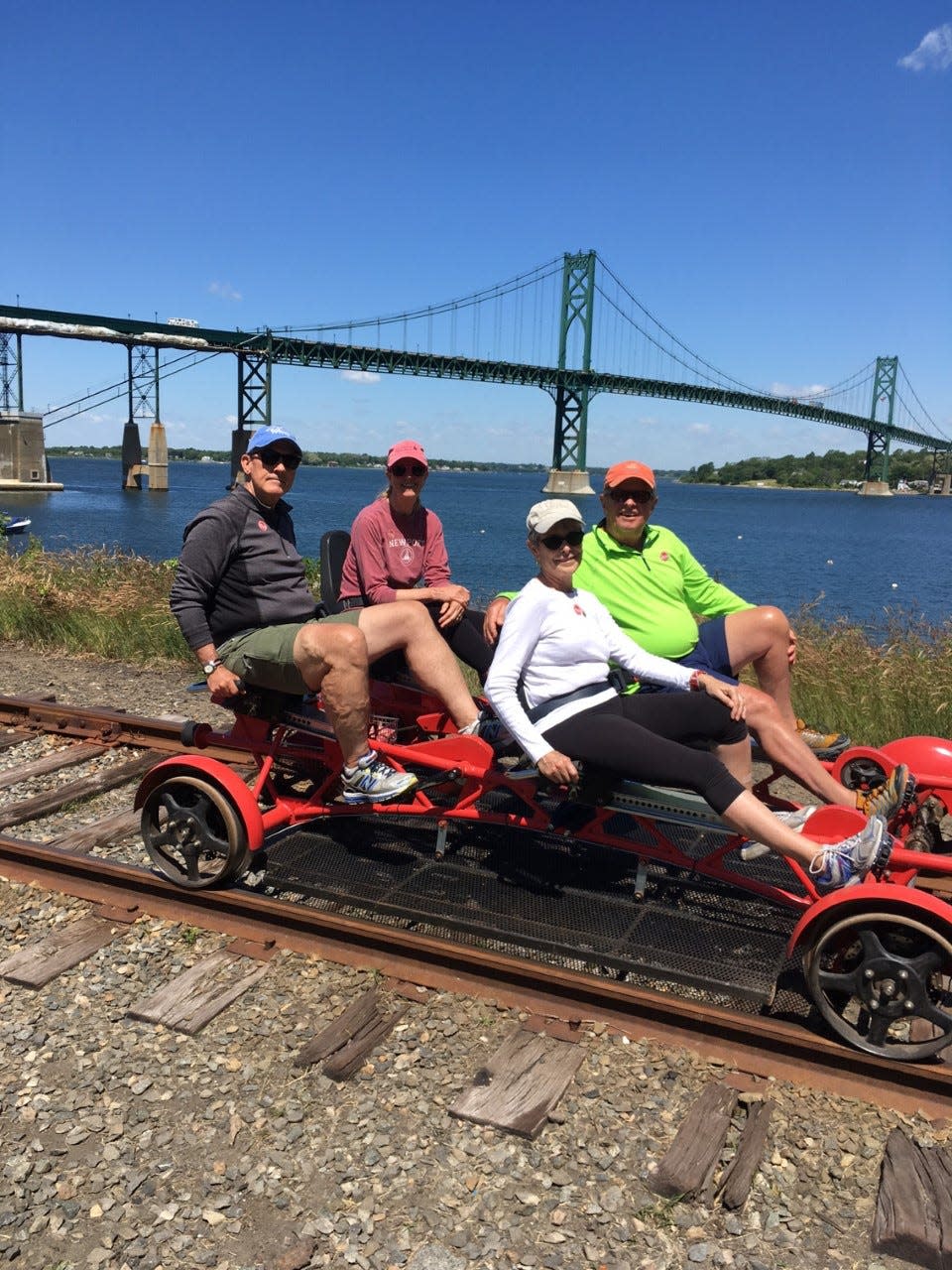 A foursome out for a ride with Rail Explorers in Portsmouth, with the Mount Hope Bridge in the background.