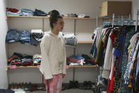 Sean Fisher, one of the student coordinators for QPLUS, the LGBTQ student organization for the College of Saint Benedict and Saint John's University, stands in the organization's dedicated lounge on the college's campus in St. Joseph, Minn., on Tuesday, Nov. 8, 2022. The lounge contains a "gender affirmation closet," with donated clothes for students exploring their gender identities, as well as clothes and accessories for the annual drag show. (AP Photo/Giovanna Dell'Orto)