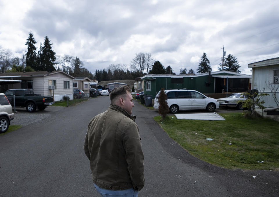 Resident and board member of the mobile home park Bob’s and Jamestown Homeowners Cooperative, Gadiel Galvez, 22, takes a walk in his neighborhood on Saturday, March 25, 2023, in Lakewood, Wash. When residents learned the park’s owner was looking to sell, they formed a cooperative and bought it themselves amid worries it would be redeveloped. Since becoming owners in September 2022, residents have worked together to manage and maintain the park. (AP Photo/Lindsey Wasson)