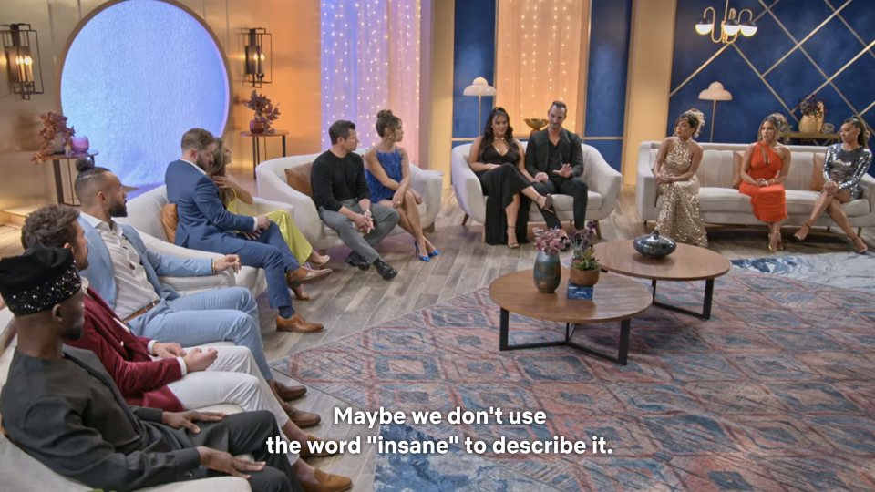 The members sitting in a semicircle on couches with the caption, "Maybe we don't use the word 'insane' to describe it"