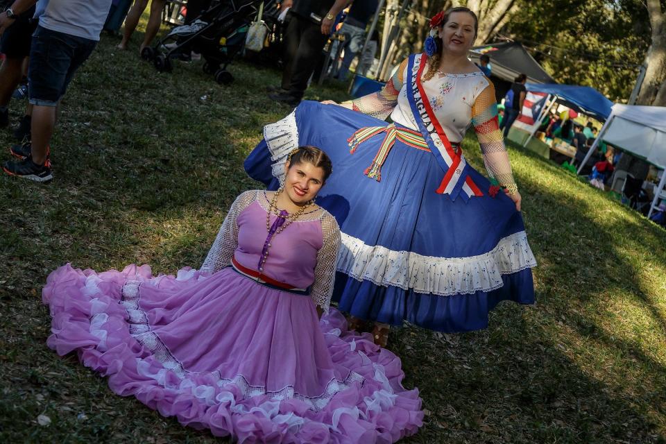 Kiara Zalazar, left and Rosana Paredes, right, display their Paraguayan dresses during the Fiesta de Pueblo celebration at Samuel J. Ferreri Community Park in Greenacres, Fla.