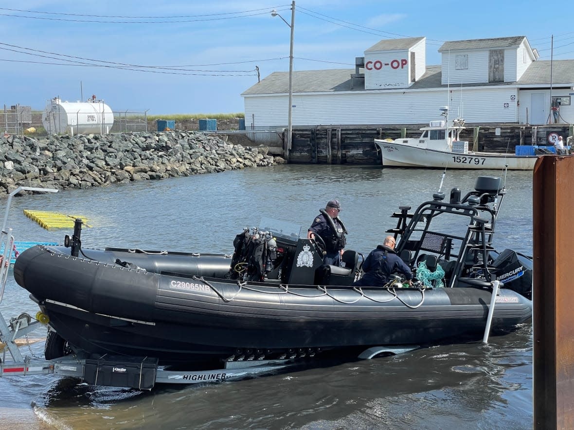 RCMP officers at the wharf in Pointe-Sapin as part of the search for Justin Landry in August. (Alexandre Silberman/CBC - image credit)