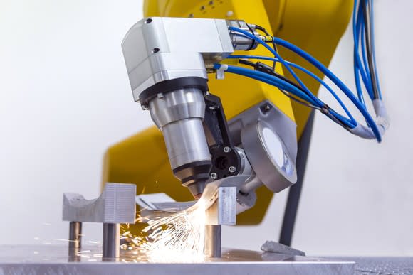 A laser on robotic arm cutting metal.