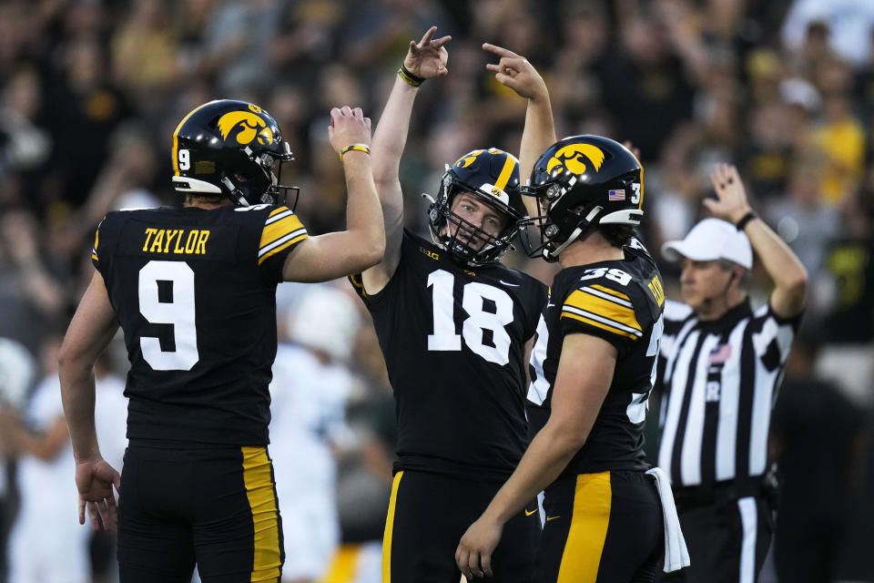 Iowa place-kicker Drew Stevens (18) celebrates with teammates Tory Taylor (9) and Luke Elkin (39) after kicking a field goal during the first half of an NCAA college football game against Michigan State, Saturday, Sept. 30, 2023, in Iowa City, Iowa. (AP Photo/Charlie Neibergall)