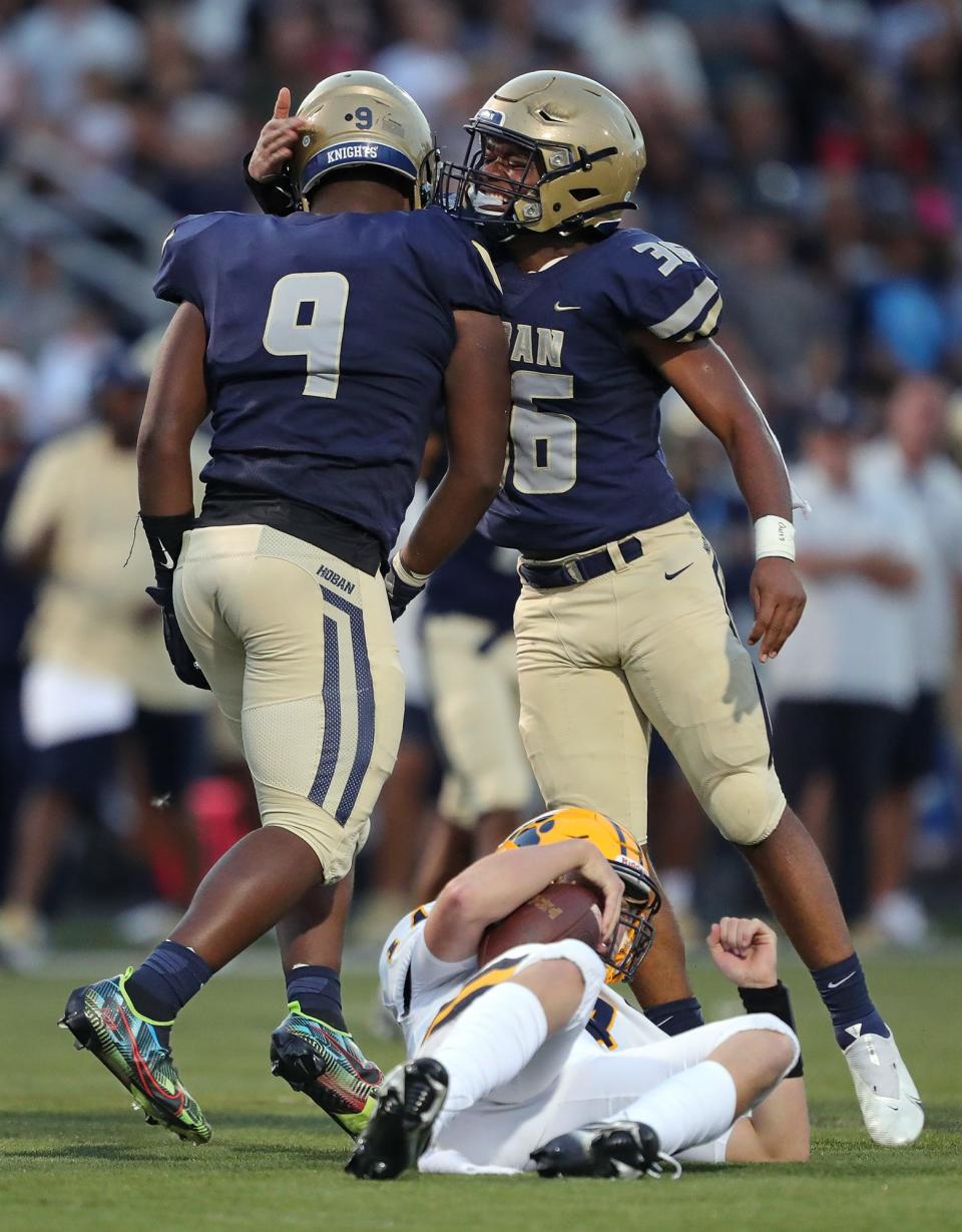 Hoban linebacker Deon Rodgers, right, celebrates with defensive end Jordan Pritchard-Sewell, left, after he sacked St. Ignatius quarterback Joshua Papesh during the first half of a high school football game, Friday, Sept. 16, 2022, in Akron, Ohio.