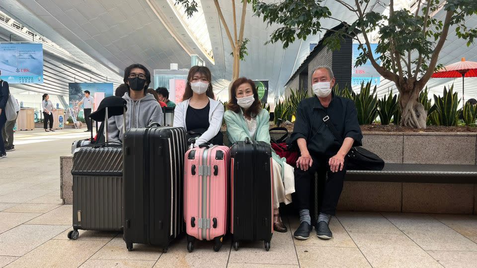 Sato Hitomi, third from left, is about to leave for Hawaii with her family from Tokyo's Haneda Airport. - Himari Semans for CNN