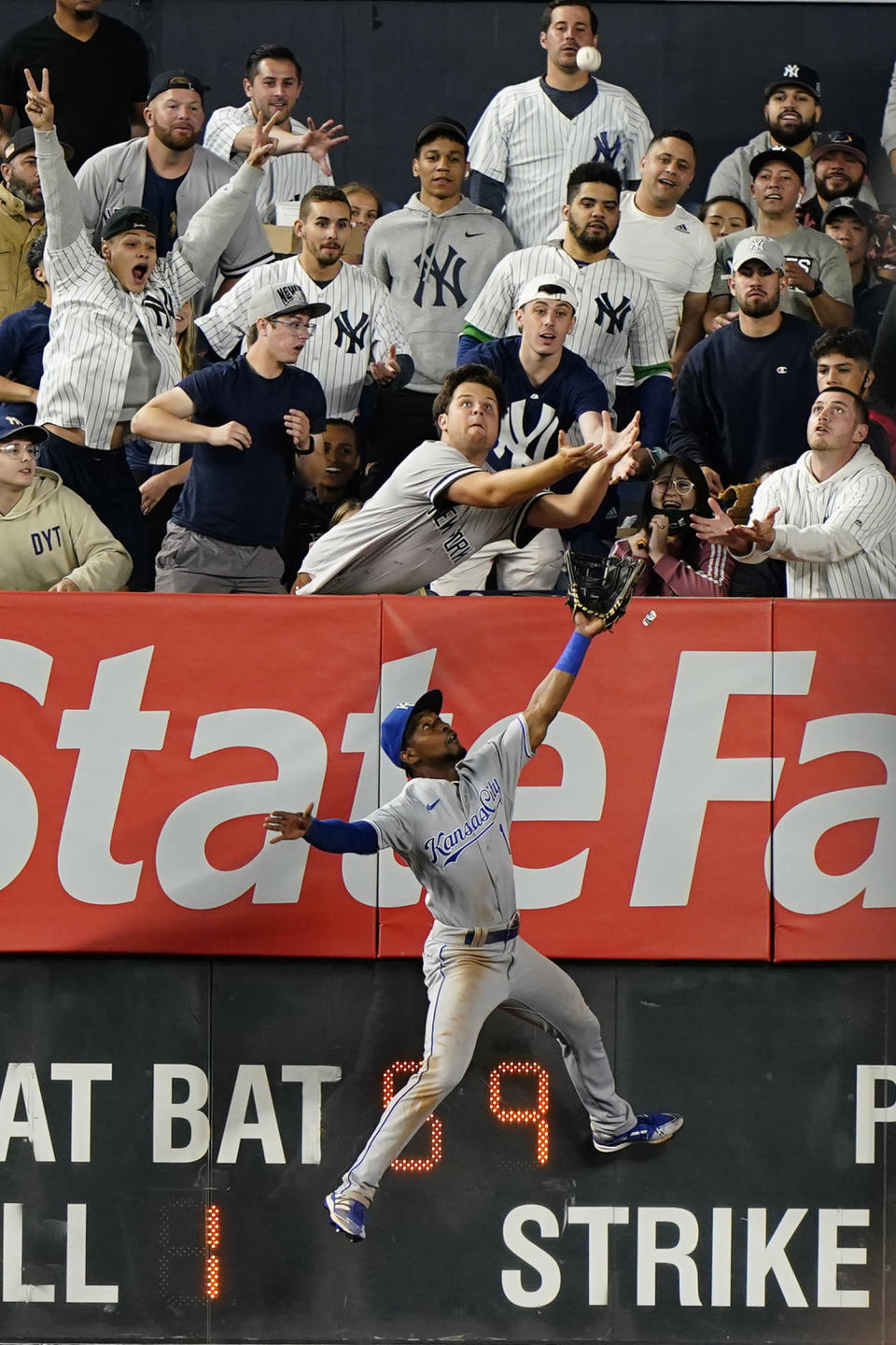 RETRANSMISSION TO CORRECT FROM DOUBLE TO TRIPLE - Kansas City Royals left fielder Jarrod Dyson (1) leaps for New York Yankees Luke Voit's seventh inning triple as fans reach for it in a baseball game Tuesday, June 22, 2021, at Yankee Stadium in New York. (AP Photo/Kathy Willens)