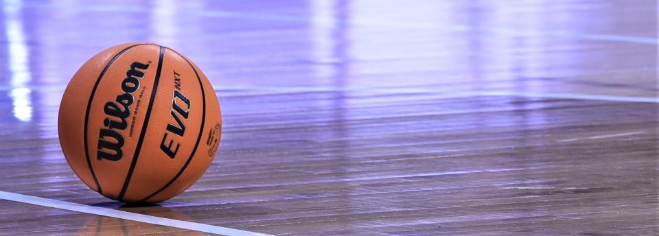 A basketball rests on court.