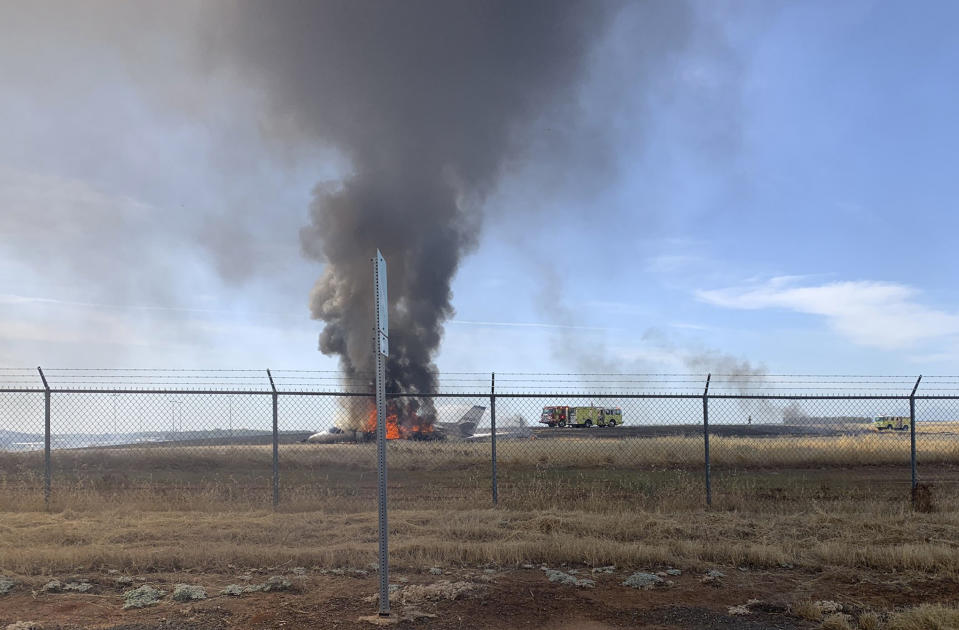 In this photo provided by the California Highway Patrol is the scene where a jet burst into flames after aborting a takeoff Wednesday, Aug. 21, 2019, in Oroville, Calif. Officials say a small jet burst into flames while trying to take off from a small Northern California airport, but all 10 people on board escaped injury. The Federal Aviation Administration says the pilot of the twin-engine Cessna Citation jet aborted its takeoff at Oroville Municipal Airport for unknown reasons shortly before noon Wednesday. The aircraft slid off the end of the runway into the grass and caught fire. The plane was flying from Oroville to Portland International Airport in Oregon. (California Highway Patrol via AP)