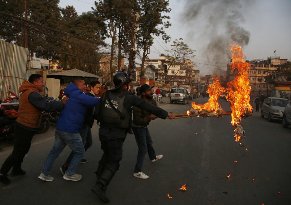 Nepalese students affiliated with Nepal Student Union burn an effigy of Nepalese prime minister Khadga Prasad Oli during a protest in Kathmandu, Nepal, Sunday, Dec. 20, 2020. Nepal’s president dissolved Parliament on Sunday after the prime minister recommended the move amid an escalating feud within his Communist Party that is likely to push the Himalayan nation into a political crisis. Parliamentary elections will be held on April 30 and May 10, according to a statement from President Bidya Devi Bhandari's office. (AP Photo/Niranjan Shrestha)