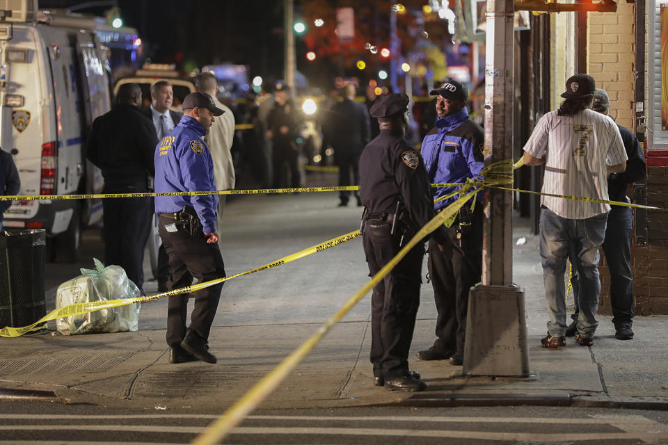 New York Police officers investigate the scene of a shooting where two police officers were injured and one person was shot, Friday, Oct. 25, 2019, in the Brownsville neighborhood of the Brooklyn borough of New York. (AP Photo/Julius Motal)