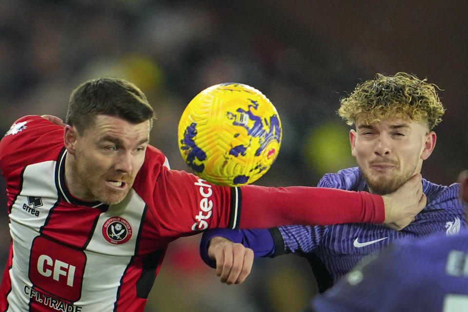 Harvey Elliott (derecha) de Liverpool y John Fleck de Sheffield United disputan el balón en el partido de la Liga Premier, el miércoles 6 de diciembre de 2023, en Sheffield. (AP Foto/Jon Super)