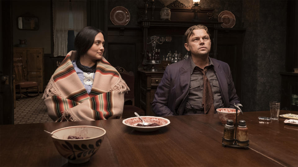 Lily Gladstone and Leonardo DiCaprio sitting at a table in Killers of the Flower Moon.