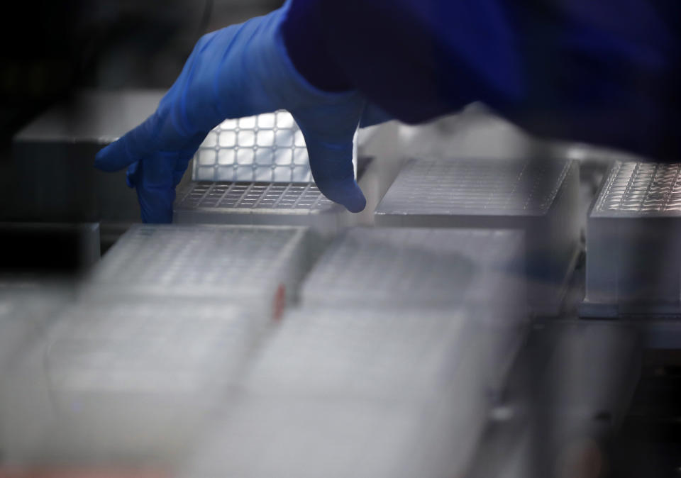 A lab assistant takes the seal of Covid-19 test assay plates to prepare for sequencing at the Wellcome Sanger Institute that is operated by Genome Research in Cambridge, Thursday, March 4, 2021.Cambridge University microbiologist Sharon Peacock understood that genomic sequencing would be crucial in tracking the coronavirus, controlling outbreaks and developing vaccines, so she began working with colleagues around the country to put together a plan when there were just 84 confirmed cases in the country. The initiative helped make Britain a world leader in rapidly analyzing the genetic material from large numbers of COVID-19 infections, generating more than 40% of the genomic sequences identified to date.(AP Photo/Frank Augstein)