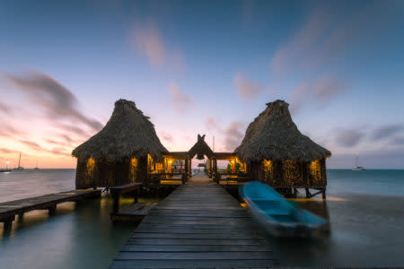 Overwater bungalow and jetty at sunset, San Pedro, Ambergris Caye, Belize.