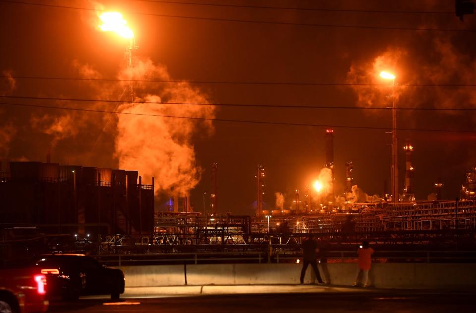 Onlookers take pictures of the Marathon Petroleum refinery after the earthquake.