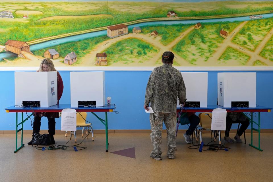 Framed by a mural, voters cast their ballots on Election Day, Tuesday, Nov. 8, 2022 inside Crooked Alley KidSpace in Groveport.