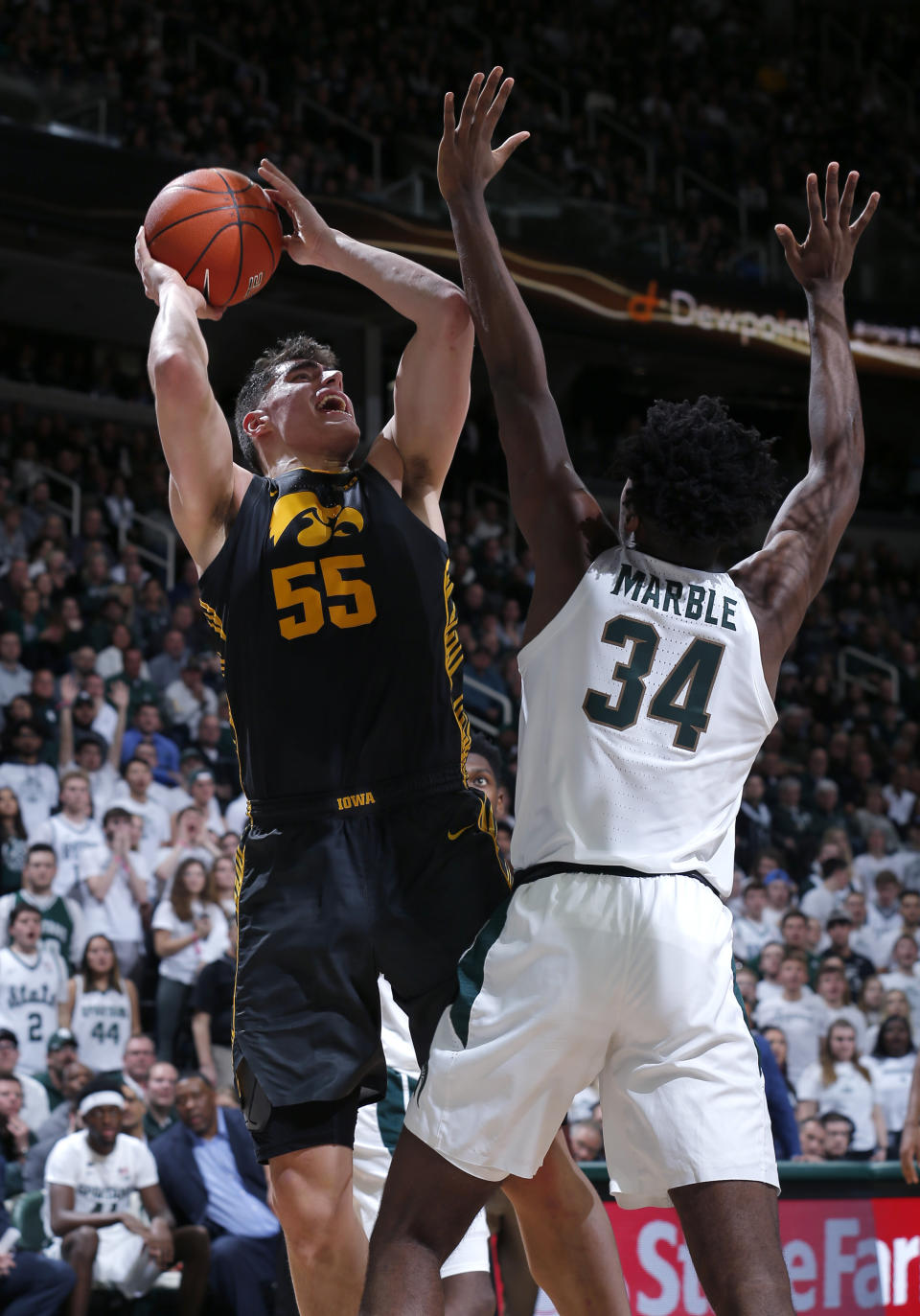 Iowa's Luka Garza, left, shoots against Michigan State's Julius Marble (34) during the first half of an NCAA college basketball game, Tuesday, Feb. 25, 2020, in East Lansing, Mich. (AP Photo/Al Goldis)