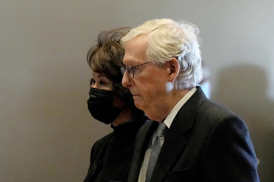 Senate Minority Leader Mitch McConnell and his wife, Elaine Chao, arrive at a memorial service for former Sen. Bob Dole, R-Kan., Saturday, Dec. 11, 2021, in Russell, Kan. (AP Photo/Charlie Riedel)