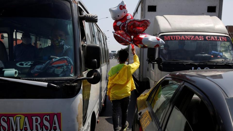 Vendedor de globos en medio del tráfico en Perú.