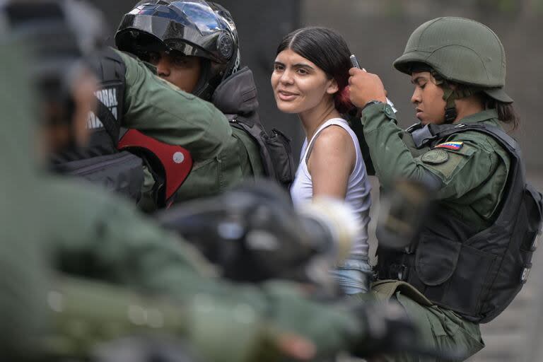 Arresto de una manifestante en el Chacao, un barrio de Caracas. (Yuri CORTEZ / AFP)
