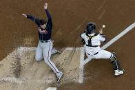 Atlanta Braves' Freddie Freeman scores past Milwaukee Brewers catcher Manny Pina during the third inning of the Game 2 in baseball's National League Divisional Series Saturday, Oct. 9, 2021, in Milwaukee. Freeman on a hit by Ozzie Albies. (AP Photo/Morry Gash)