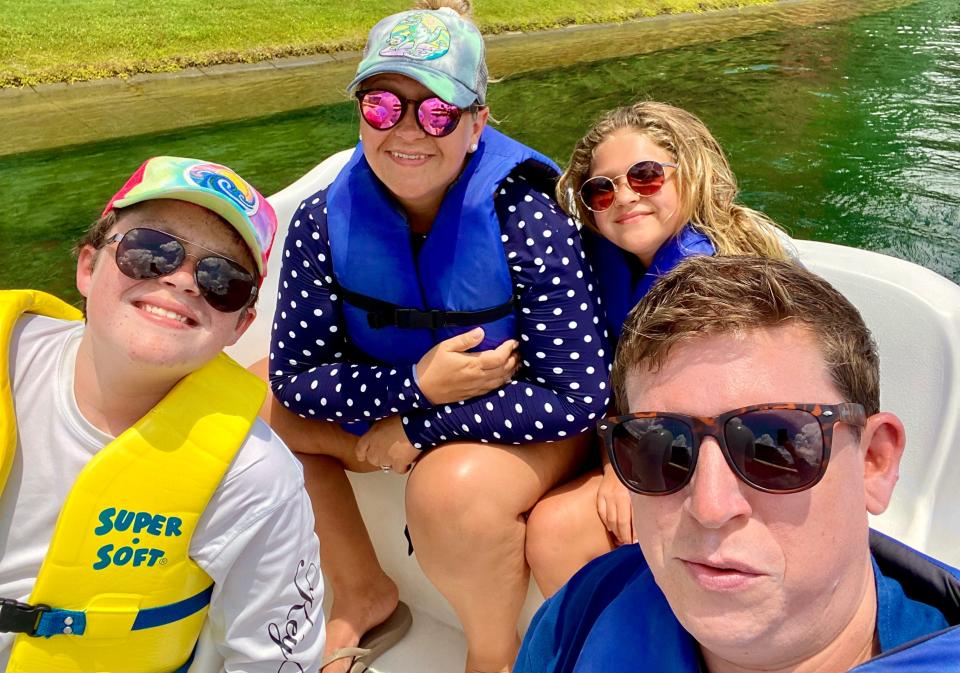 Terri Peters, her two kids, and husband wearing life vests on a boat in Florida