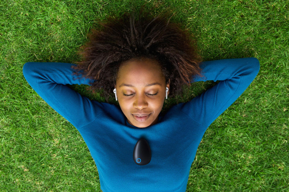 A woman wearing a Sensate device around her neck