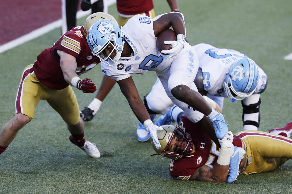 Boston College linebacker Isaiah McDuffie, bottom, stops North Carolina running back Michael Carter (8) during the first half of an NCAA college football game, Saturday, Oct. 3, 2020, in Boston. (AP Photo/Michael Dwyer)