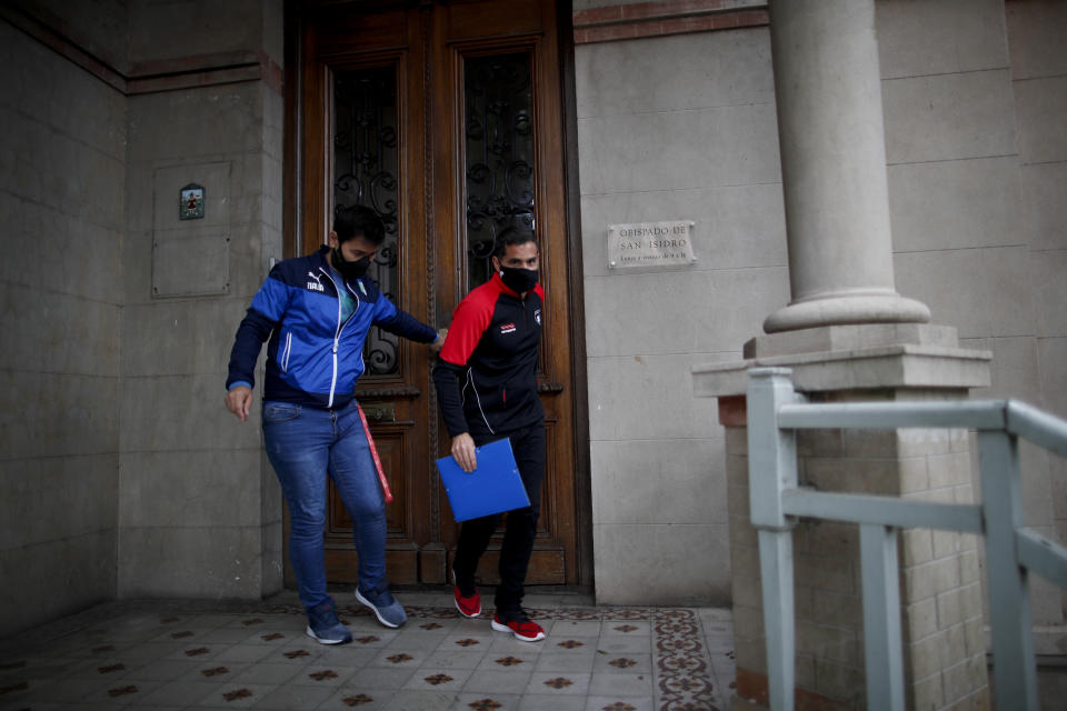 Former Catholic Priest Andres Gioeni, right, leaves the bishopric with his husband Luis Iarocci, where he started the process of apostasy in Buenos Aires, Argentina, Wednesday, March 17, 2021. Gioeni, who left the priesthood 20 years ago and married in 2014, said he has decided to formally leave the church after the Vatican decreed that the Catholic Church cannot bless same-sex unions since God ‘cannot bless sin.’ (AP Photo/Natacha Pisarenko)