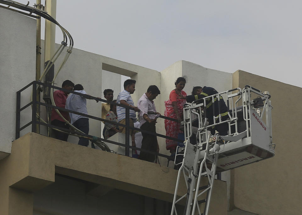 People are rescued from a nine-story building with offices of a state-run telephone company during a fire in Mumbai, India, Monday, July 22, 2019. (AP Photo/Rafiq Maqbool)