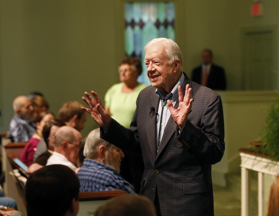 Former President Jimmy Carter welcomes visitors to Maranatha Baptist Church before teaching Sunday school in Plains, Ga, Sunday, June 8, 2014. (AP Photo/John Bazemore)