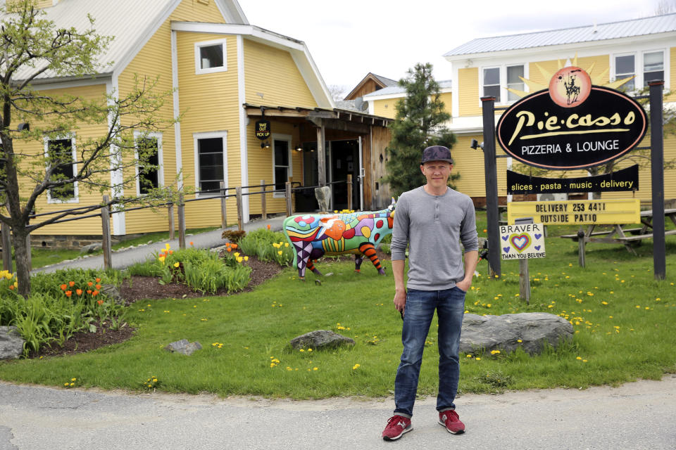 Eduardo Rovetto poses outside his restaurant Piecasso Pizzeria & Lounge in Stowe, Vt., on Saturday, May 8, 2021. Rovetto says he would like to hire between 15 and 20 workers before what is expected to be a busy summer tourist season, but he’s not getting enough interest. Similar complaints are heard across the country and many states, including Vermont, are beginning to push those who lost jobs during the pandemic back into the workforce. (AP Photo/Wilson Ring)