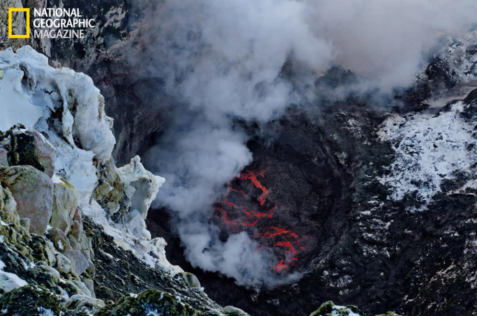 A study in contrasts: ice and snow in the foreground, the lava lake of Mount Erebus below. Erebus is one of just a handful of volcanoes to boast a permanent lava lake. At the moment this picture was taken, the volcano was quiet, but it frequently erupts, hurling lava bombs high in the air. (photo © Carsten Peter/National Geographic)