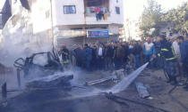 People gather at a site of a car bomb blast at the Syrian city of Latakia, Syria in this handout released by SANA on January 22, 2019 .SANA/Handout via REUTERS